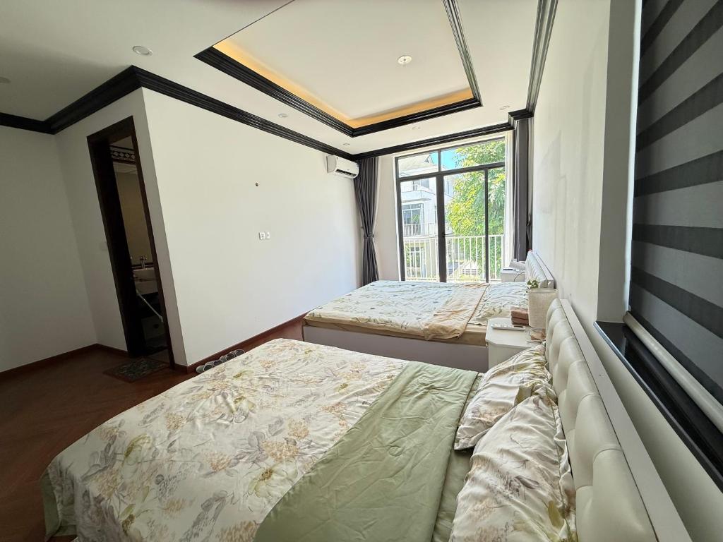 Un dormitorio con dos camas y una ventana. en Ana La Vie Hue, en Thôn Lại Thê