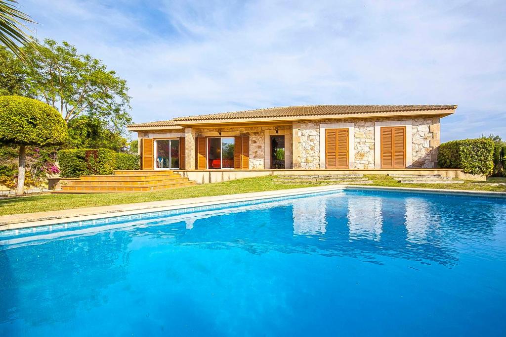 a house with a swimming pool in front of a house at YupiHome Finca s'Aubac in Sa Pobla