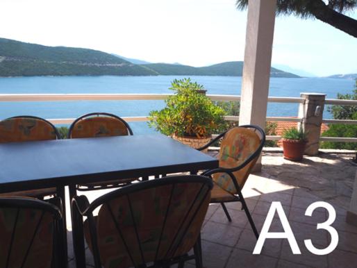 a blue table and chairs with a view of the water at Apartmani ROKO in Neum