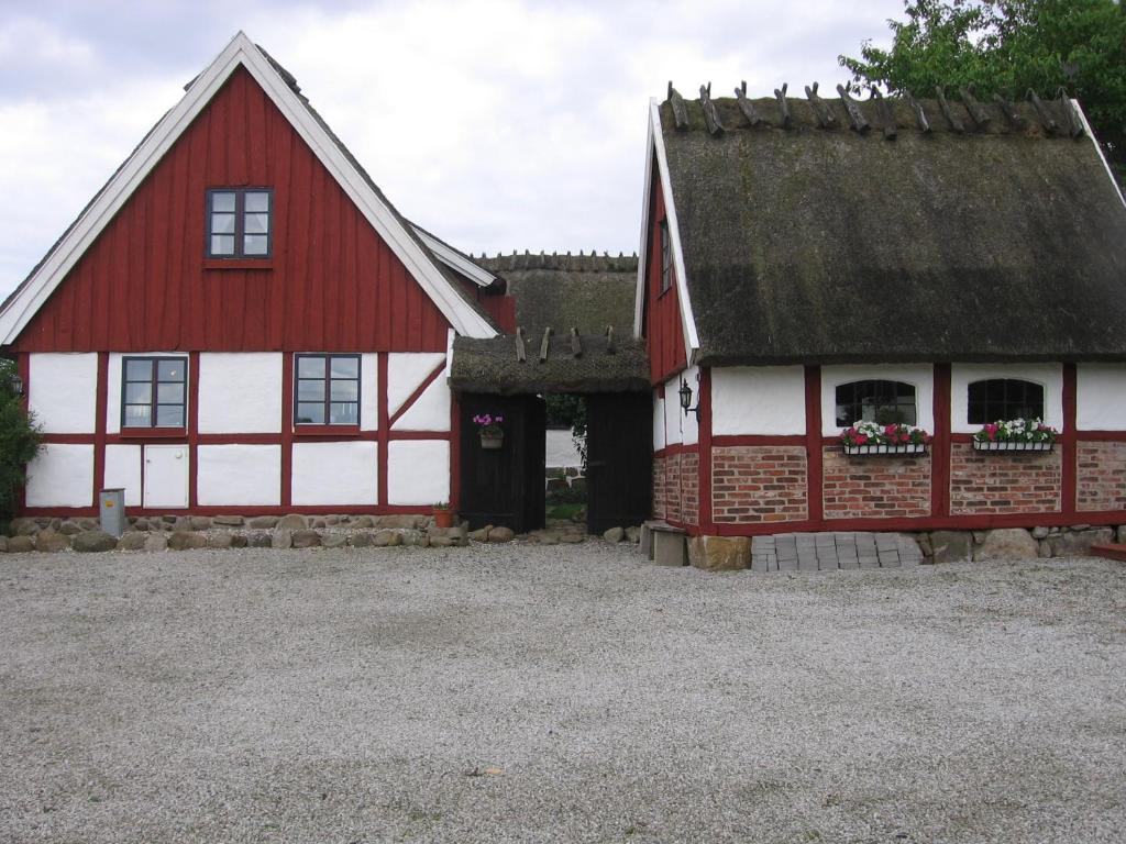 eine rot-weiße Scheune mit einem Dach in der Unterkunft B&B Hannåsa Gård in Hammenhög