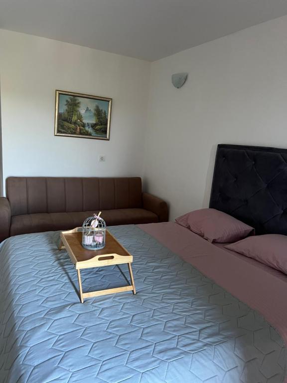 a room with a bed with a table and a couch at Apartmani Gazivode in Budva
