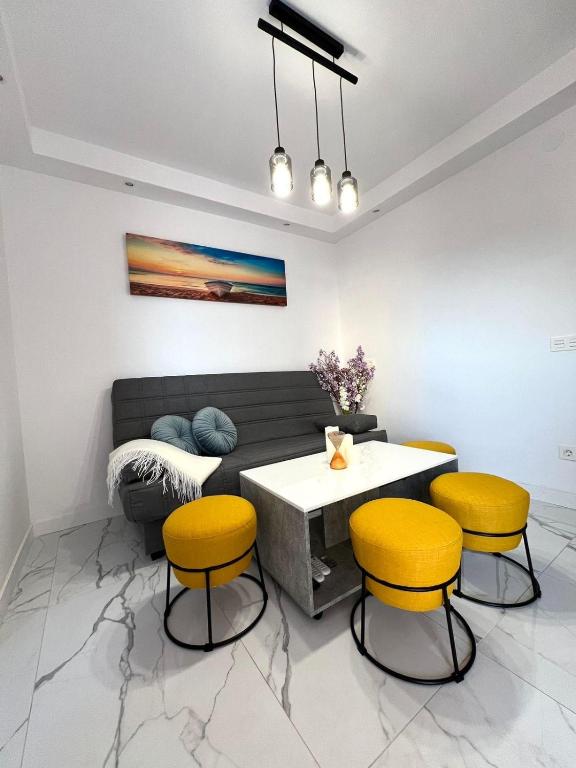 ein Wohnzimmer mit einem Tisch und gelben Stühlen in der Unterkunft Aguadulce bay apartments 1 in Aguadulce