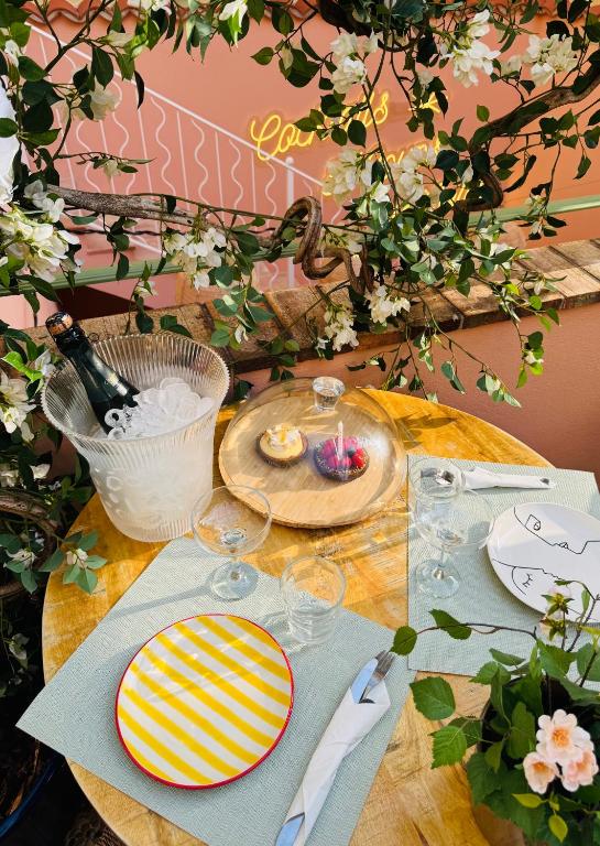 a wooden table with plates and wine glasses on it at Hôtel Gabriel in Menton