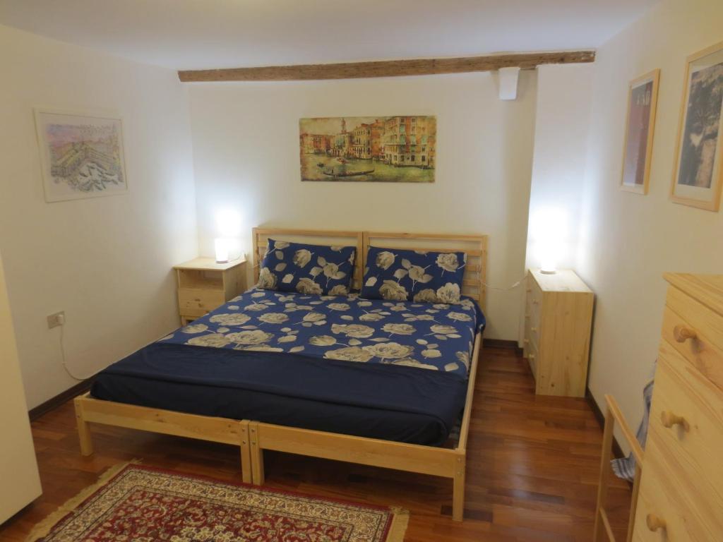 a bedroom with a bed with a blue comforter at Apartment Ca Dragan in Venice