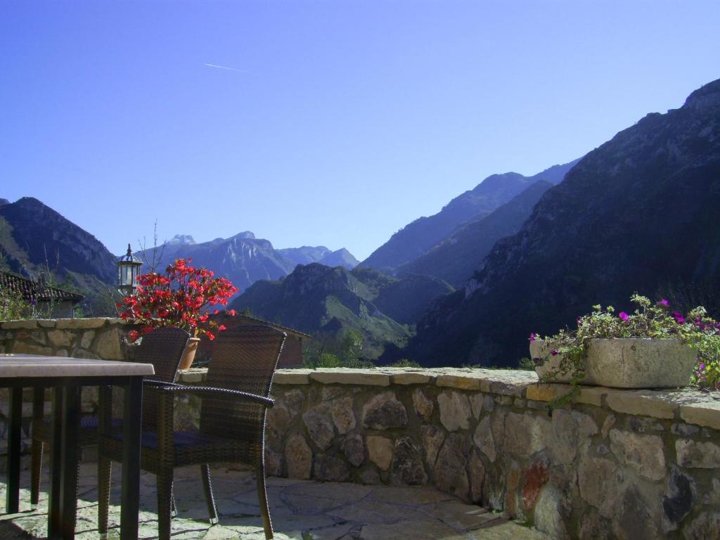 a patio with a table and chairs and mountains at La Casona de Sames in Sames