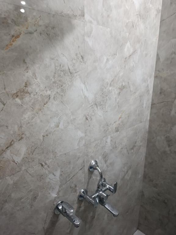 a shower with two faucets in a bathroom at Home stay in varanasi by gaurav in Ahraurā Road