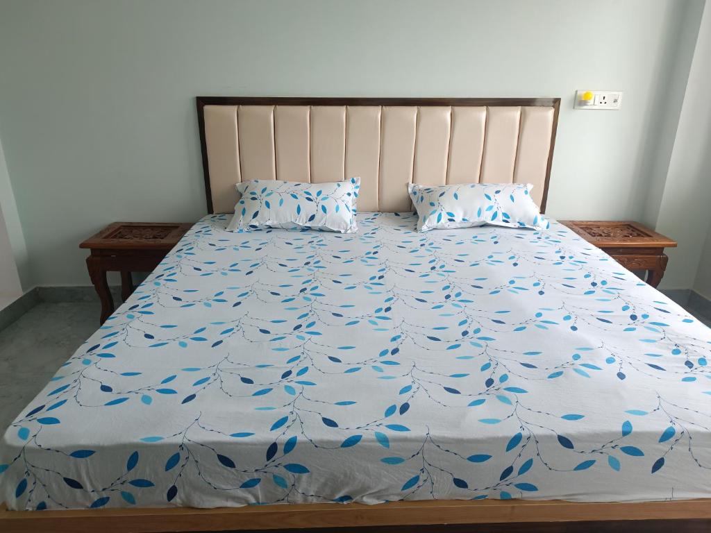 a bed with a blue comforter and two pillows at Home stay in varanasi by gaurav in Ahraurā Road