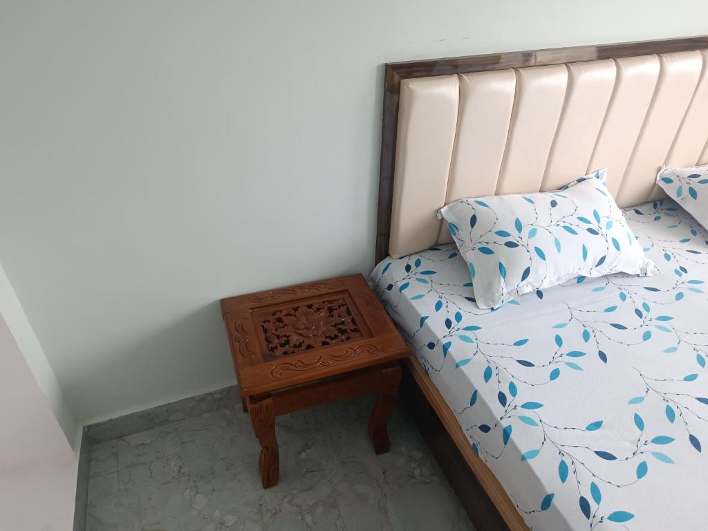 a bed with a night stand next to a bed with a pillow at Home stay in varanasi by gaurav in Ahraurā Road