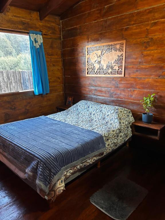 Un dormitorio con una cama en una cabaña de madera. en Cabaña De Montaña Ámber II, en San Carlos de Bariloche