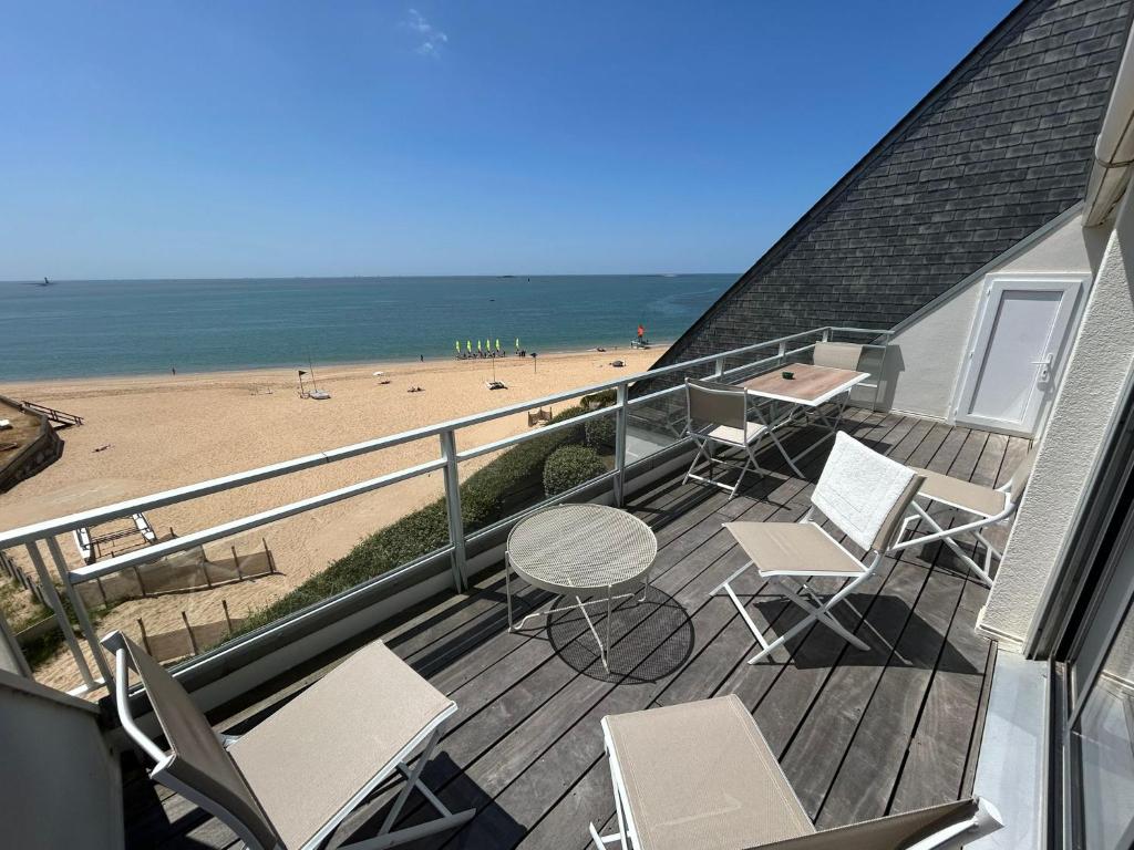 - un balcon avec des chaises, une table et une plage dans l'établissement Duplex Vue mer Saint Marguerite, à Pornichet