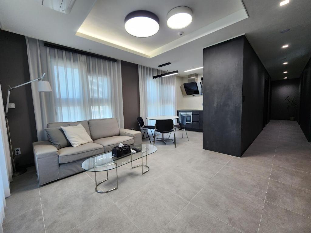 a living room with a couch and a table at SoYou osiria residence in Busan