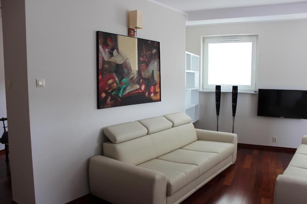 sala de estar con sofá blanco y TV en Ustka Apartament Na Wydmie en Ustka
