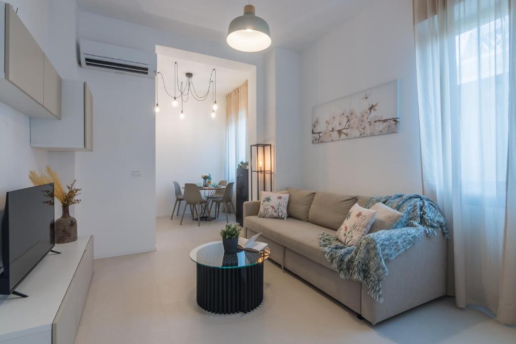 Hotel Moderno bilocale a 90m dal mare con posto auto - Residence Cinzia, a living room with a couch and a table at Moderno bilocale a 90m dal mare con posto auto - Residence Cinzia in Rimini