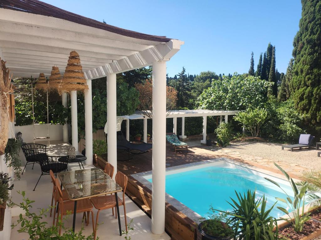 a patio with a table and a swimming pool at Villa Jalna bis in Béziers