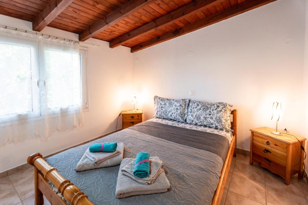 a bedroom with a bed with towels on it at Cozy Beachfront Cottage with Sea Loungers & Outdoor Shower near Eretria in Eretria