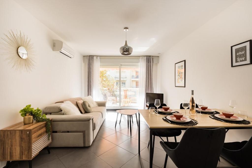 a living room with a couch and a table at Air conditioned apartment, 3 min walk to the beaches, Garage in Antibes