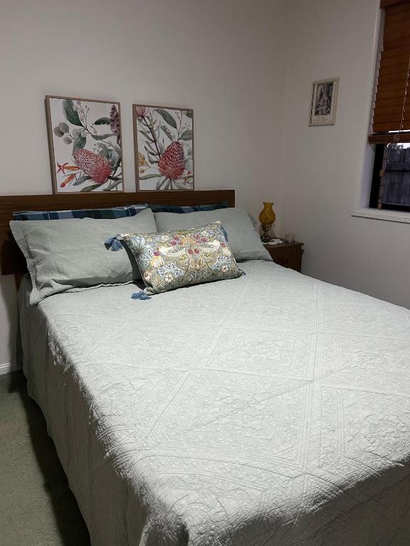 a bed with a pillow on it in a bedroom at Orchid House Shared in Stanthorpe