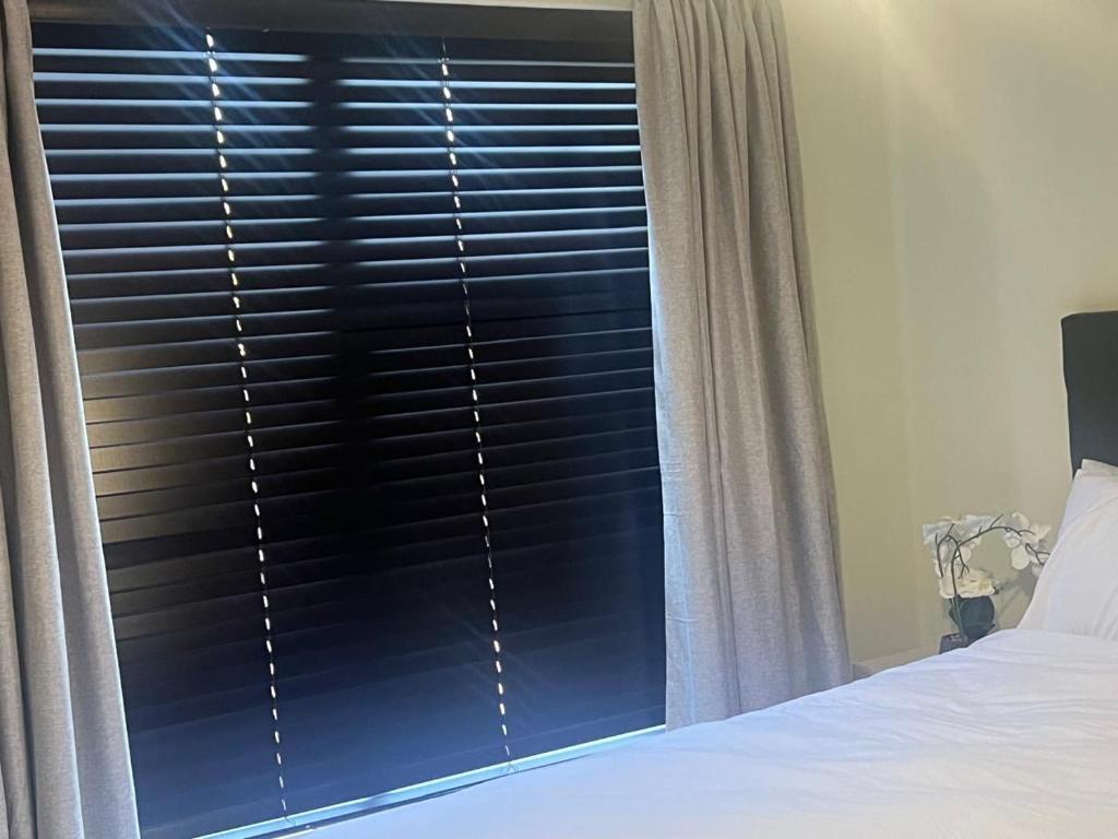 Un dormitorio con una ventana con persianas negras. en The Nest at Greenstone Gate, en Vosburg