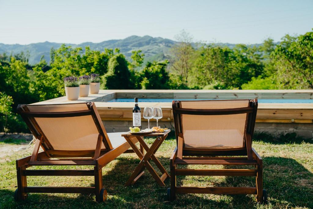 two chairs and a table with a bottle of wine at La Casa dei Caprioli in Bubbio