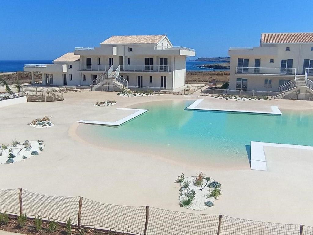 a large swimming pool in front of a building at Francy s Marzamemi Home in Marzamemi