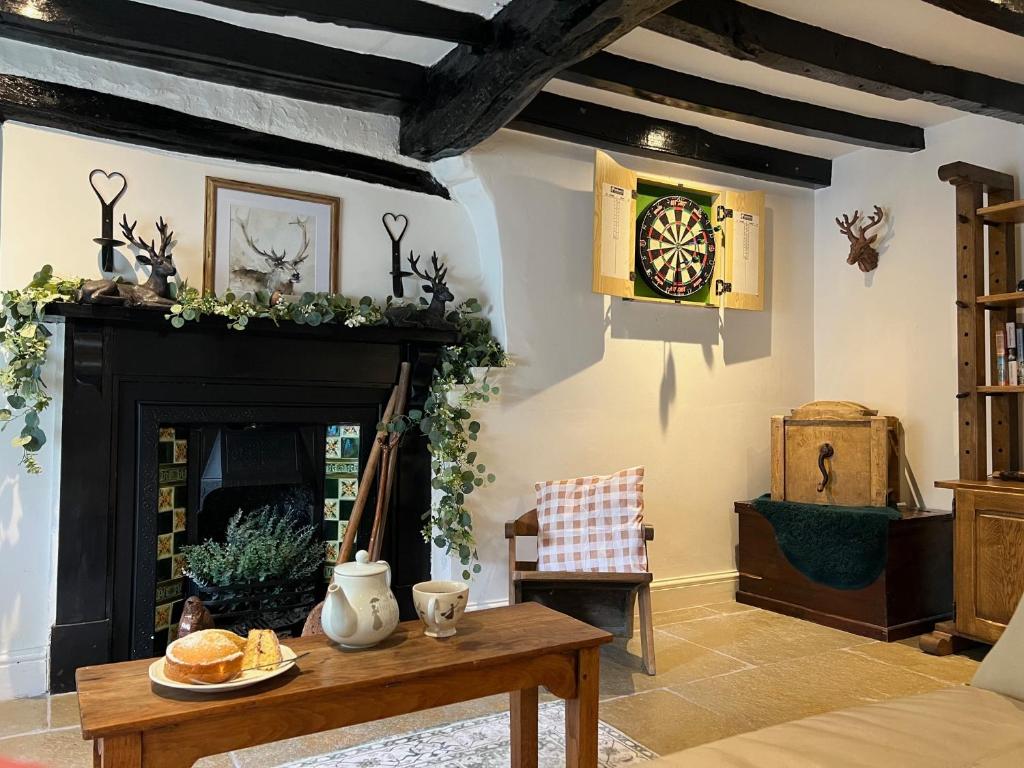 a living room with a fireplace and a clock on the wall at Blue Bell Cottage in Ollerton