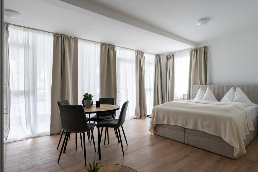 a hotel room with a bed and a table and chairs at FarawayHomes Studio Fohnsdorf #13 in Fohnsdorf