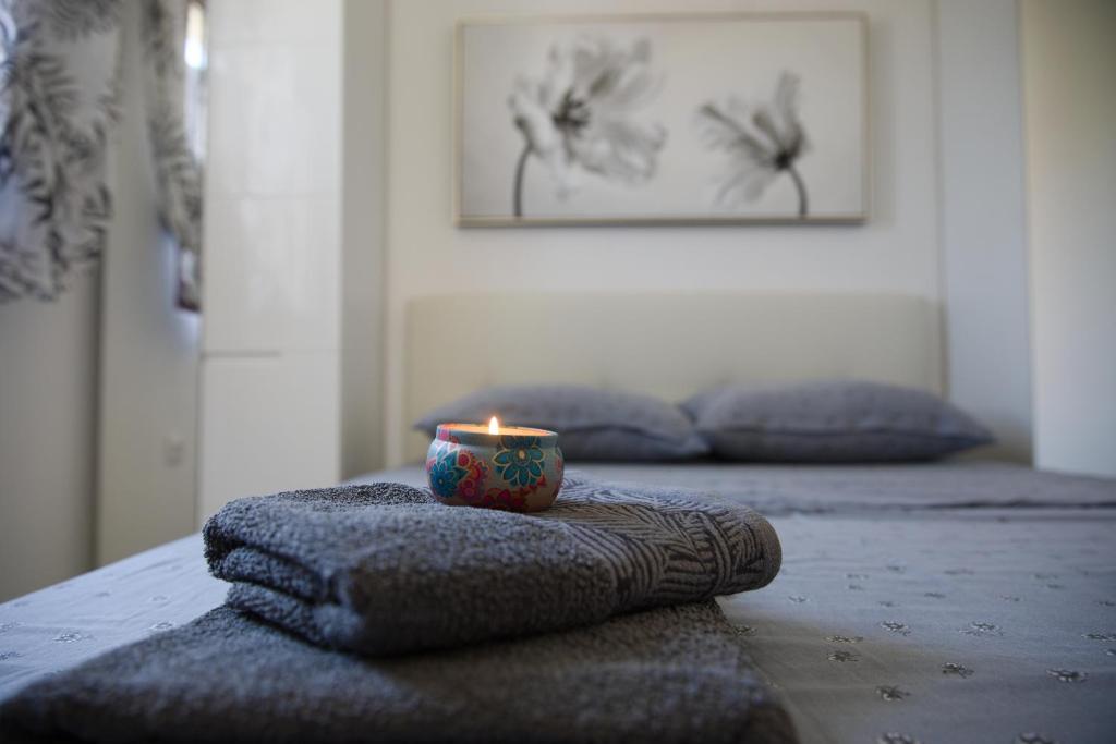 a candle sitting on top of towels on a bed at Apartmány Suzi number 1 in Privlaka