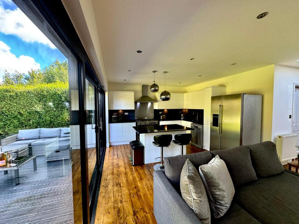 a living room with a couch and a kitchen at Zarza House 4 bedroom Home Sleeps 8 large Garden wifi and free Parking in Hatfield