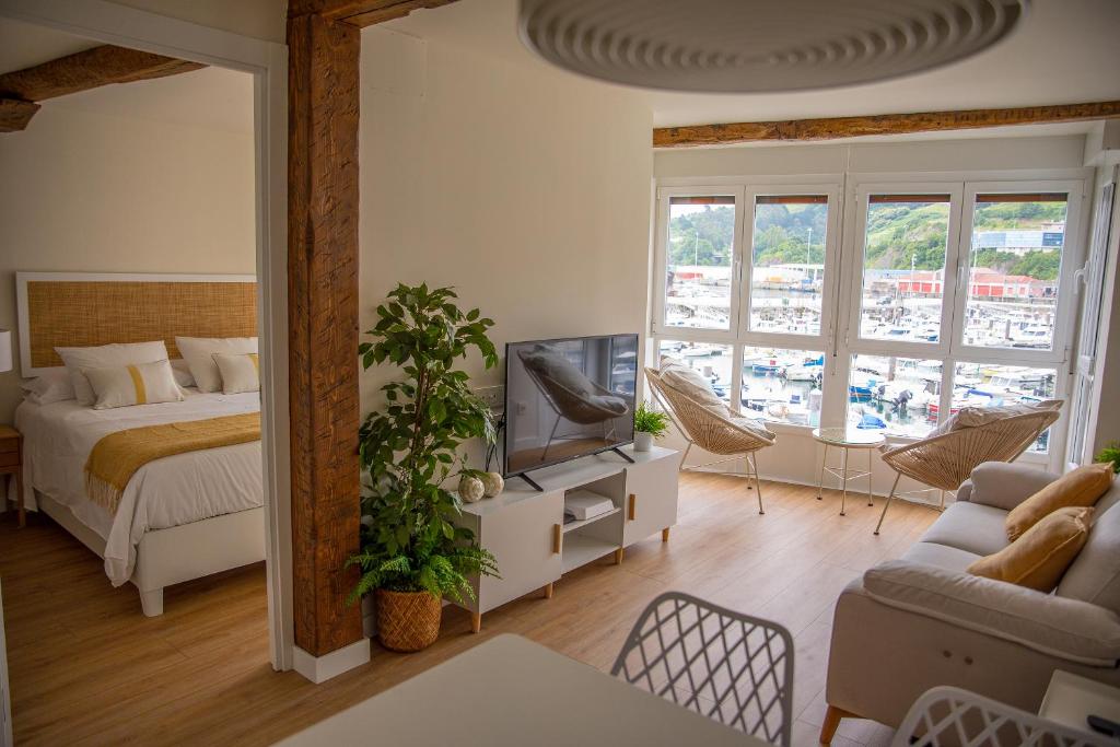 a bedroom with a bed and a tv in a room at TxOKO ETXEA in Bermeo