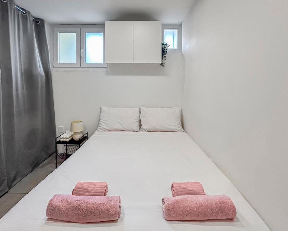 een slaapkamer met een groot bed met 2 roze kussens bij Studio Centre Ville proche TRAM & Port, Wifi Gratuit in Nice