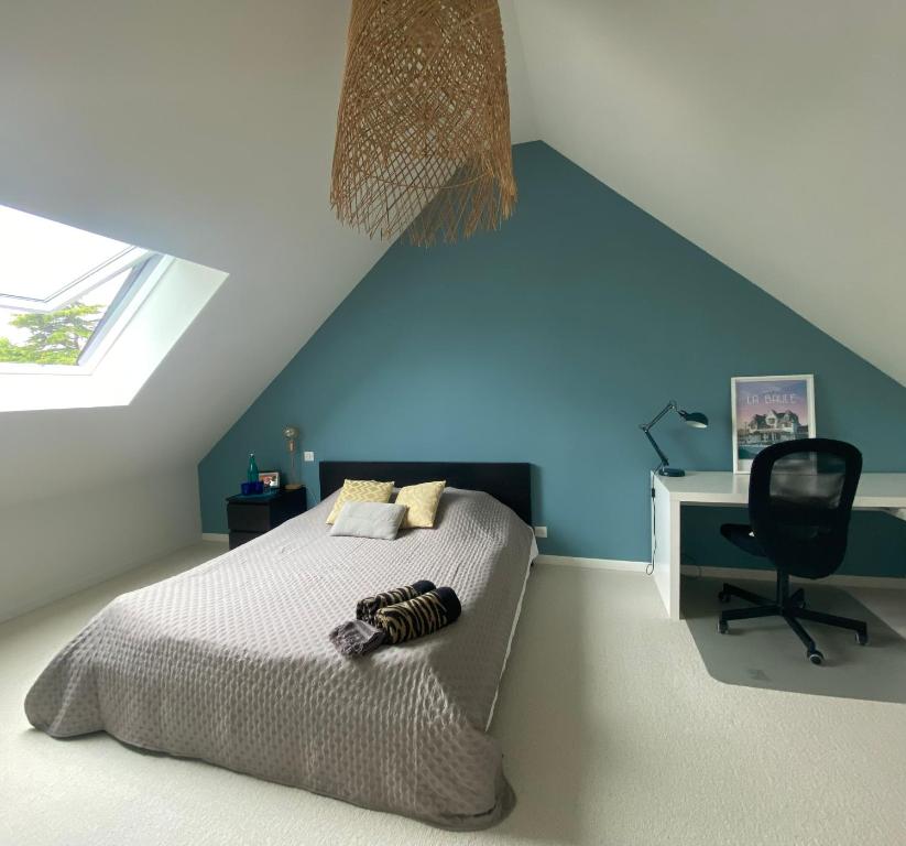 une chambre avec un lit et une chaise dans un grenier dans l'établissement Chambres d’hôtes au calme, proche de la mer, à Saint-Nazaire