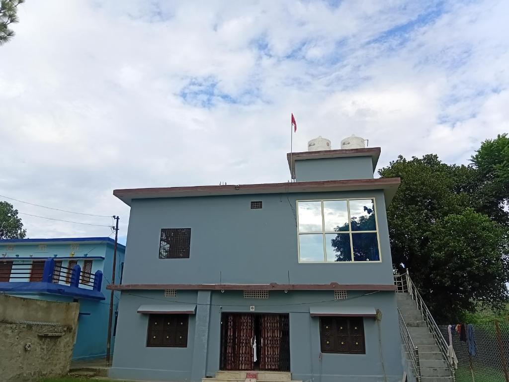 a blue building with a tower on top of it at Corbett view homestay in Belparāo