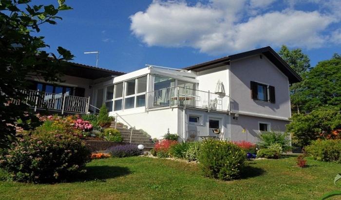 a white house with a balcony and a yard at Ferienwohnung in Gamlitz