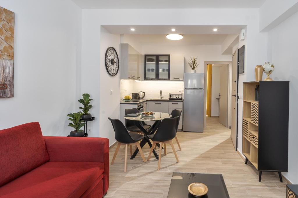 a living room with a red couch and a kitchen at Pap's Lab Apartments in Heraklio