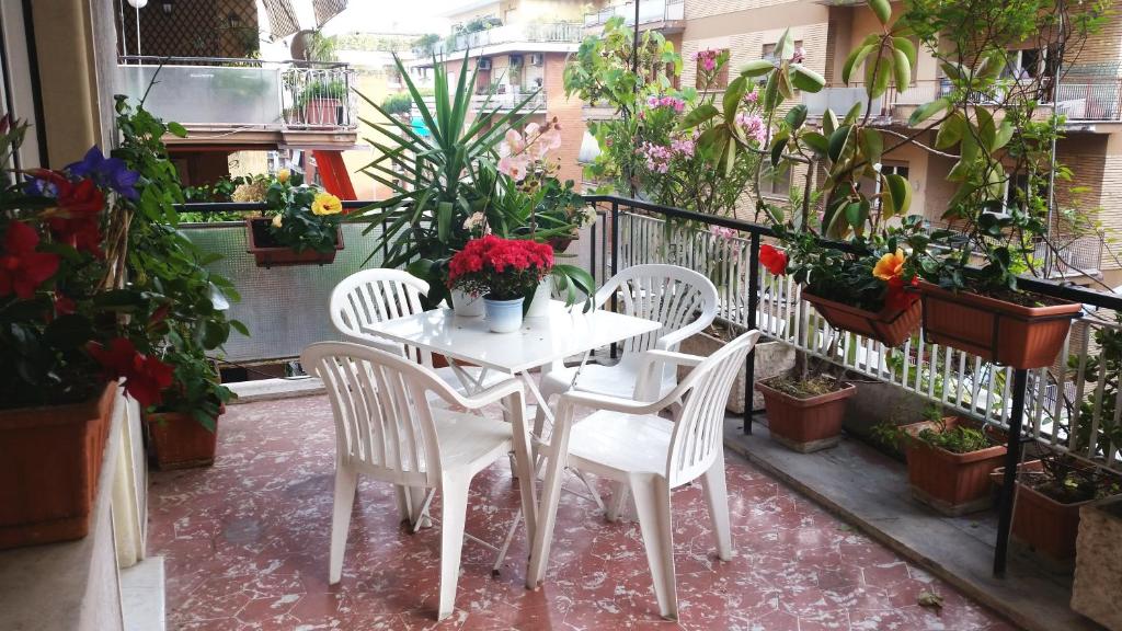 a white table and chairs in a balcony with plants at Vatican De Carolis Terrace in Rome