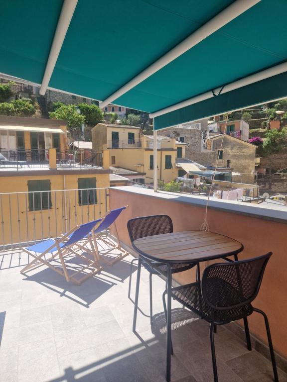 a patio with a table and chairs on a roof at Sailor and the Moon in Riomaggiore