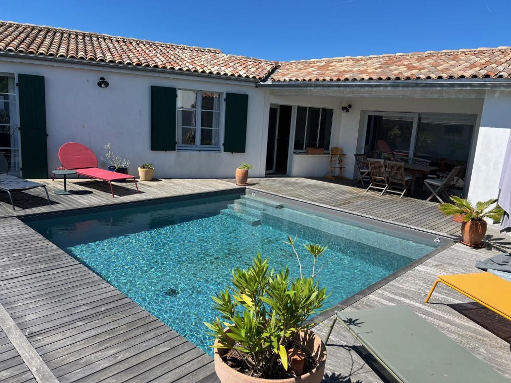 ein Swimmingpool vor einem Haus in der Unterkunft La Villa des Alouettes avec piscine chauffee in Sainte-Marie-de-Ré
