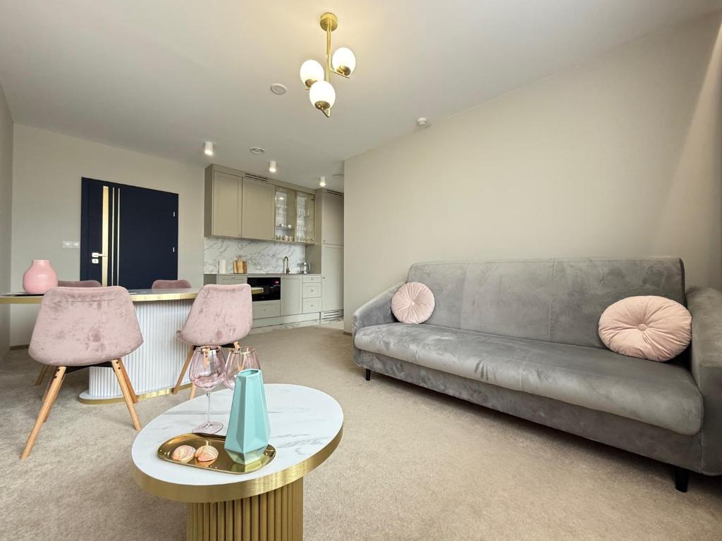 een woonkamer met een bank en een tafel bij CONTINENTAL Apartamenty Piamola in Krynica Morska