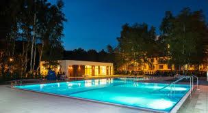 a large swimming pool with blue water at night at Balticstars apartments polanki in Kołobrzeg