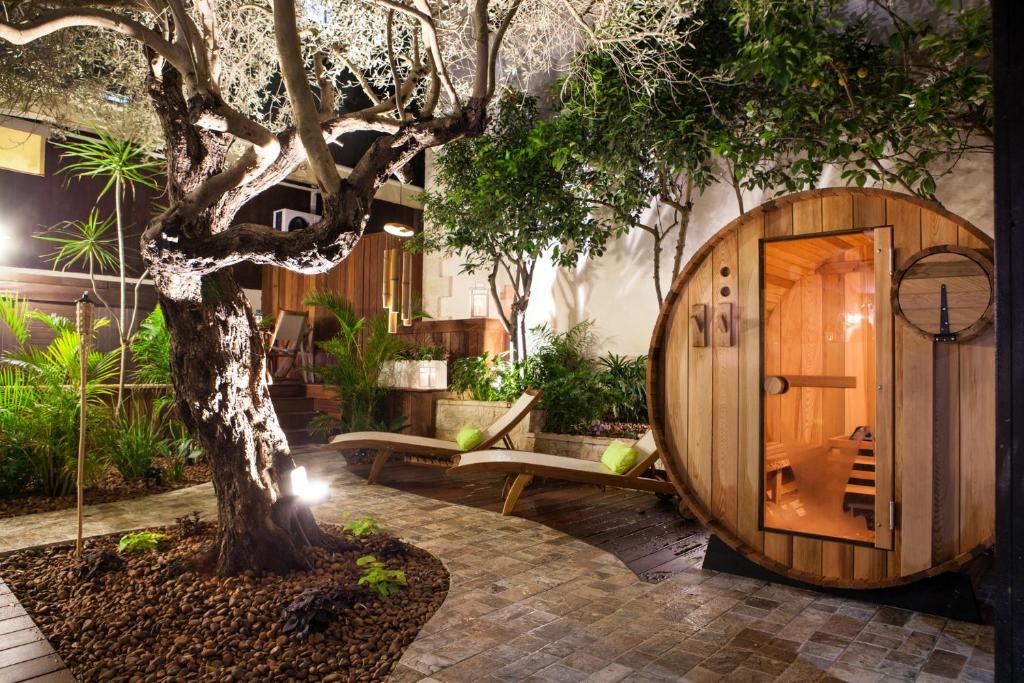 a tree in front of a building with a wooden door at Carmel Pearl in Haifa