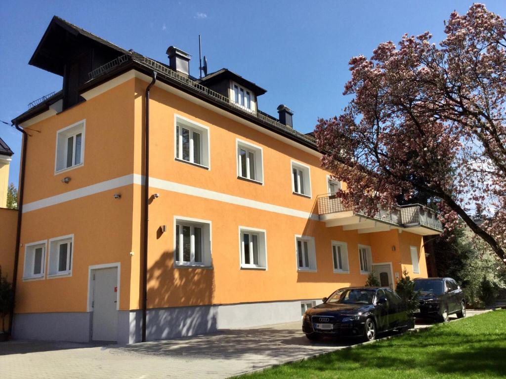 a building with two cars parked in front of it at Salzburgrooms in Salzburg