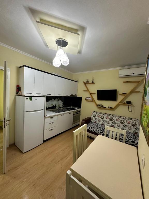 a kitchen with a white refrigerator and a table at Krena Apartament in Durrës