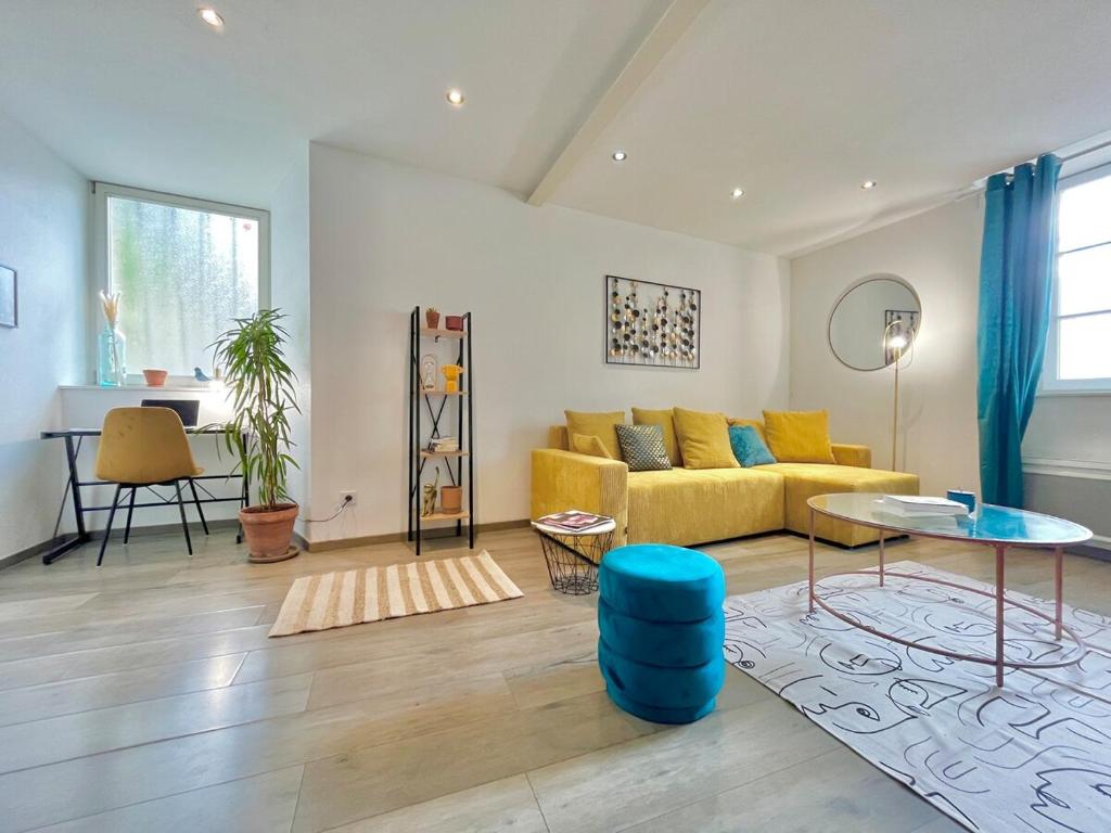 un salon avec un canapé jaune et une table dans l'établissement Romance sur les Remparts - Route des Vins, à Rouffach