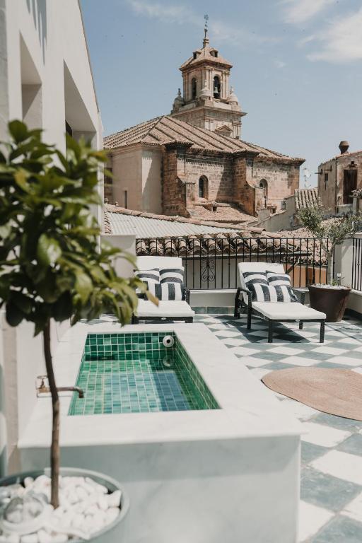 a potted tree on a patio with a building at Domus Templi in Caravaca de la Cruz
