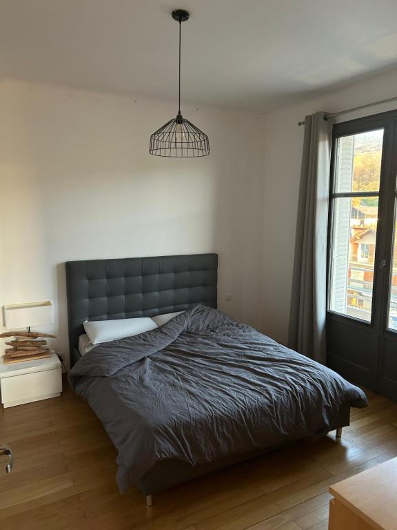 a bedroom with a bed and a pendant light at Résidence le Lumina in Maxilly-sur-Léman