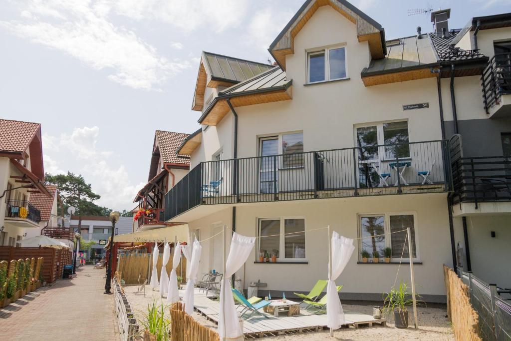 a building with white umbrellas in front of it at Pensjonat Lazytown in Pogorzelica