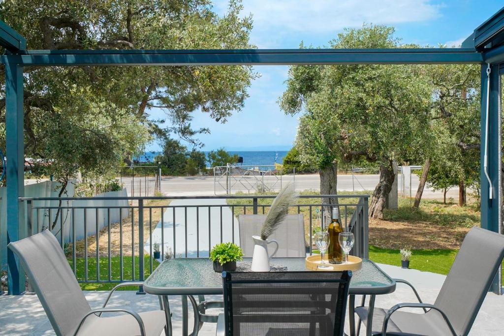 a table and chairs on a patio with a view of the ocean at Sunelia Thassos in Skala Kallirachis