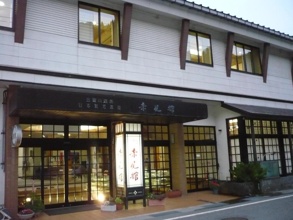 a building with an asian writing on the front of it at Gokayama Onsen Akaokan in Nanto
