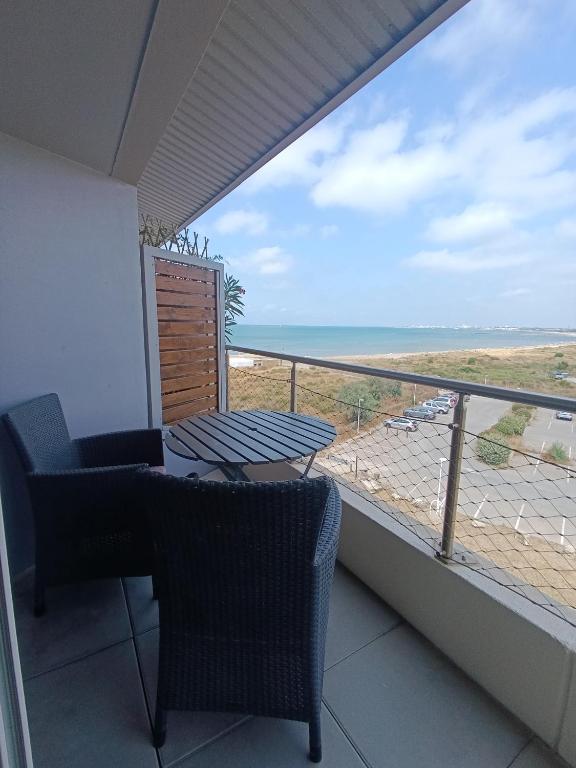 un balcon avec une table et des chaises et une vue sur l'océan dans l'établissement AS14629 - P2 Mezzanine avec vue mer latérale, dans une résidence sur plage avec parking privé, au Grau-du-Roi