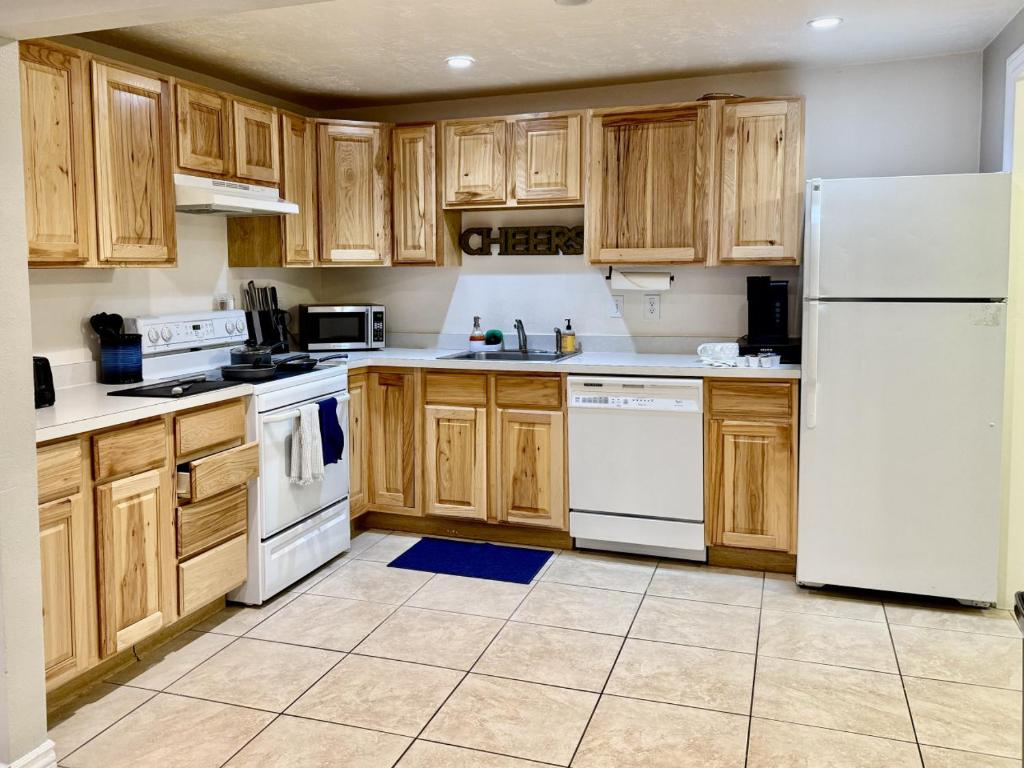 eine Küche mit weißen Geräten und Holzschränken in der Unterkunft Charming Provo Home close to BYU and Utah Lake in Provo